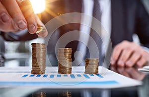 Businessman stacking coins on table, business growth concept. Hand puts coin to stack.