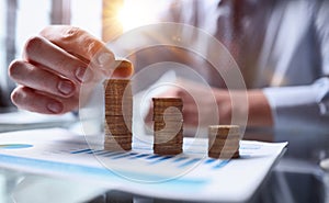 Businessman stacking coins on table, business growth concept. Hand puts coin to stack.