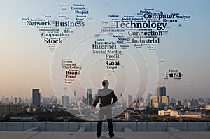 Businessman stand on roof top of skyscraper examine word cloud