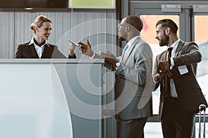 businessman standing at airport check in counter, hurry up