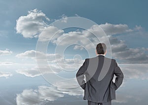 Businessman standing back to the camera with hands on hip