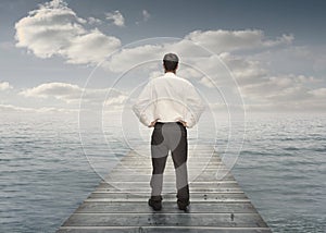 Businessman standing on a bridge with hands on hips