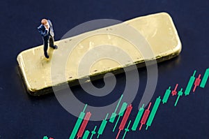 Businessman standing on the candlestick chart with gol