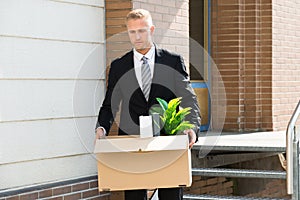 Businessman Standing With Cardboard Box