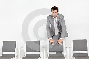 Businessman standing by chairs in waiting room
