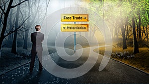 Businessman standing at crossroad having to decide between `free trade` and `protectionism`