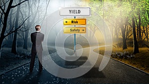 Businessman standing at a crossroad of Yield