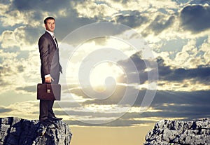 Businessman standing on the edge of rock gap