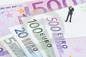 Businessman standing on the Euro banknote