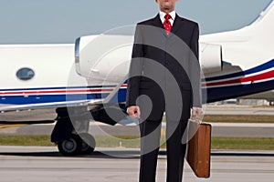 Businessman standing in front of corporate jet