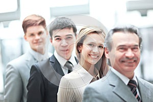 Businessman standing in front of his business team on blurred office background