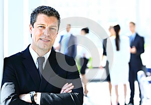 Businessman standing in front of his colleagues in office