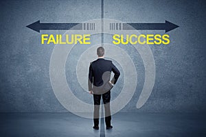 Businessman standing in front of success and failure arrow conce