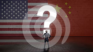 Businessman standing in front of a wall with a questionmark and the flags of the usa and china