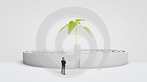 A businessman standing in front of a white round maze with a new green plant growing from its center.