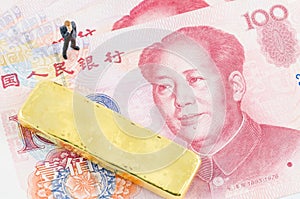 Businessman standing with gold bar on the Chinese Yuan