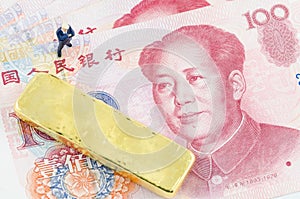 Businessman standing with gold bar on the Chinese Yuan