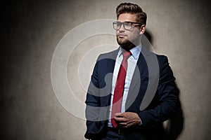Businessman standing with hand in pocket and grabbing tie