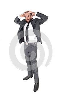 A businessman standing with hands behind head