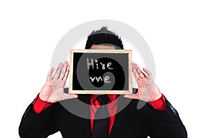 Businessman standing and holding black board with hire me message