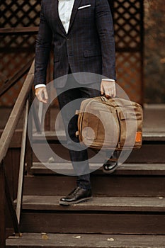 Businessman standing and holding a briefcase in hand working with confidence