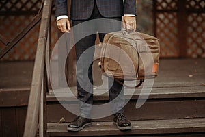 Businessman standing and holding a briefcase in hand working with confidence