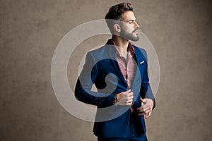 Businessman standing and holding hands on his jacket`s button