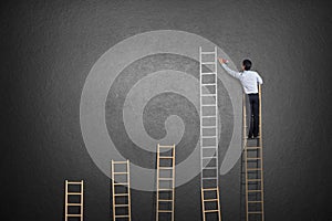 Businessman standing on ladder