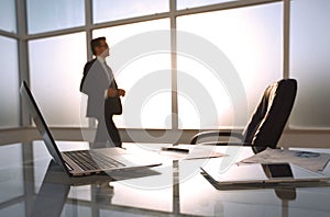 Businessman standing and looking out the window in the conference room