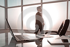 Businessman standing and looking out the window in the conference room