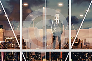 Businessman standing and looking out the window of the office at