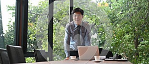 A businessman is standing in the meeting room.