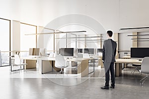 Businessman standing in modern coworking office interior w