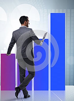 Businessman standing next to bar chart in business concept