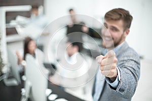 Businessman standing in the office and pointing the finger at you