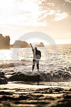 Businessman standing on the rocky coast of the ocean