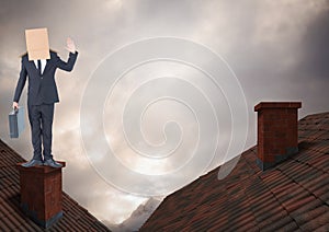 Businessman standing on Roofs with chimney and cardboard box on his head and dramatic light cloudy s