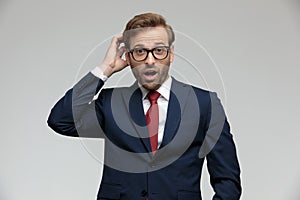 Businessman standing and scratching his head shocked
