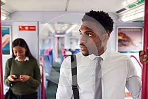 Businessman Standing In Train Commuting To Work