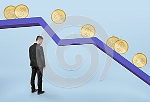Businessman standing under falling graph with golden coins rolling down