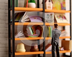 Businessman staring at bookshelf contemplating knowledge