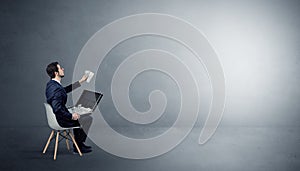 Businessman staying in an empty room with stuffs on his lap