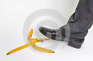 Businessman stepping on banana peel - business risk concept