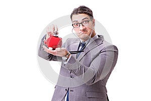 Businessman with stethoscope and piggybank isolated white backgr