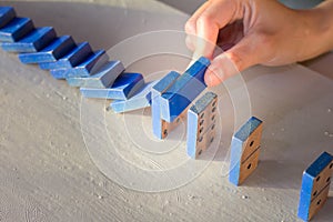 Businessman stop domino effect. Risk management concept