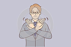 Businessman stops deal by demonstrating forbidding gesture and crossing arms in front of chest