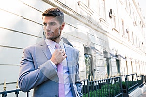 Businessman straightens his tie photo