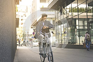 Businessman on street driving bike and checking tome on