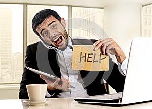 Businessman in stress holding help sign multitasking overwhelmed in business district office