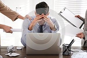 Businessman stressing out at workplace in office photo